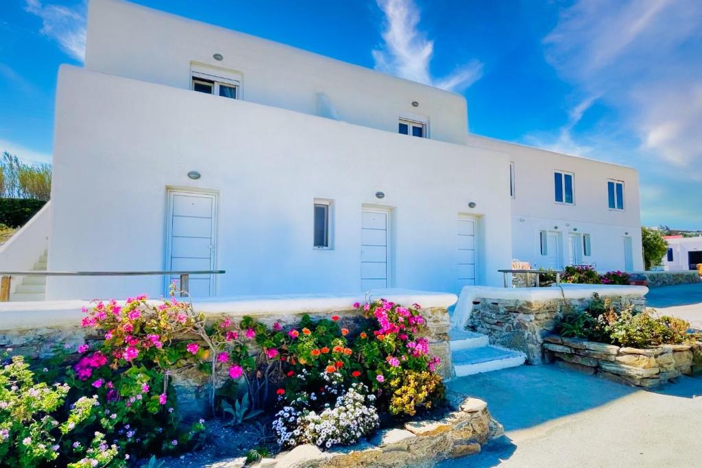 une maison blanche avec des fleurs devant elle dans l'établissement Kalimera Appartament, à Mykonos