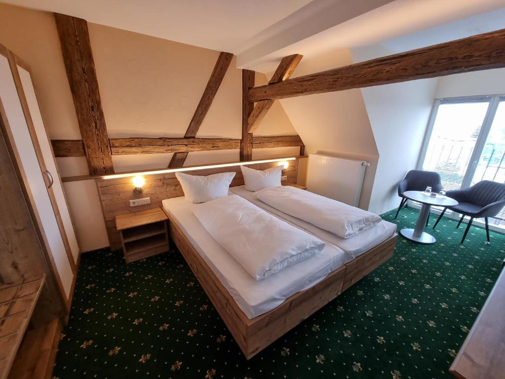 Peitz的住宿－祖姆金獅酒店，一间卧室配有一张大床和一张桌子及椅子