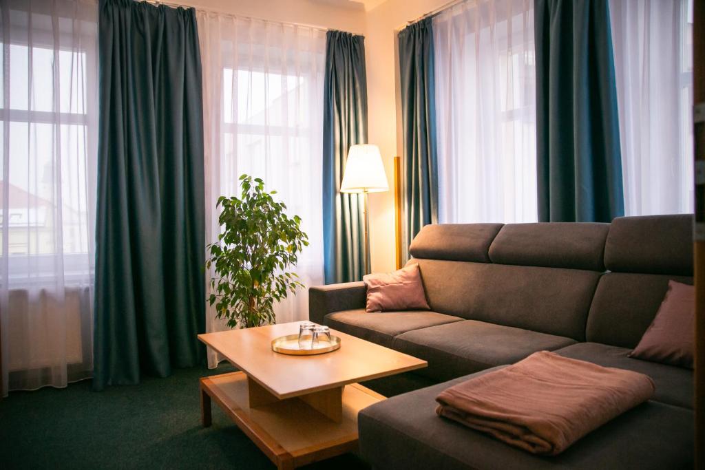 uma sala de estar com um sofá e uma mesa em Penzion Hotelu Central em Dvur Králové nad Labem