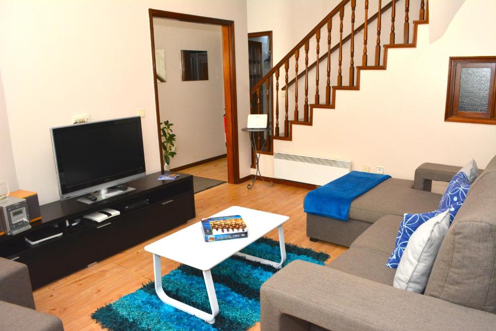 a living room with a couch and a tv at Casa do Mirante in Porto