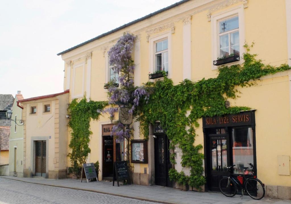 a building with purple flowers on the side of it at Penzion Kamenne Slunce in Telč