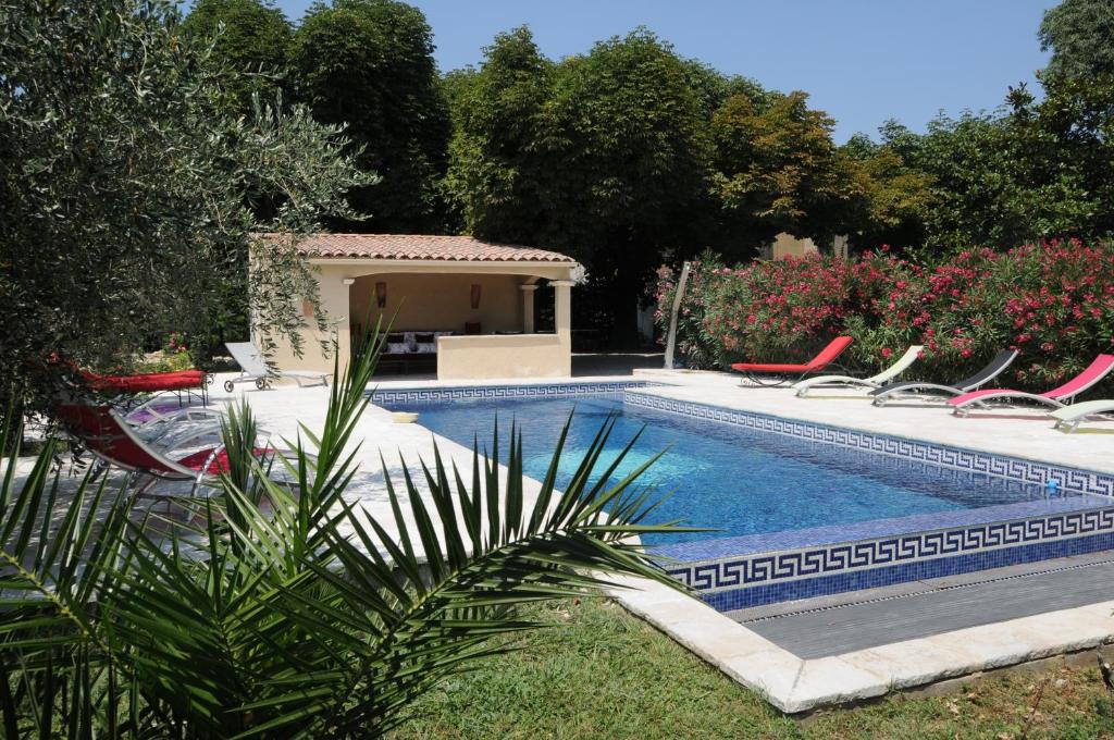 uma piscina num quintal com cadeiras à volta em bastide St Joseph em Eyguières