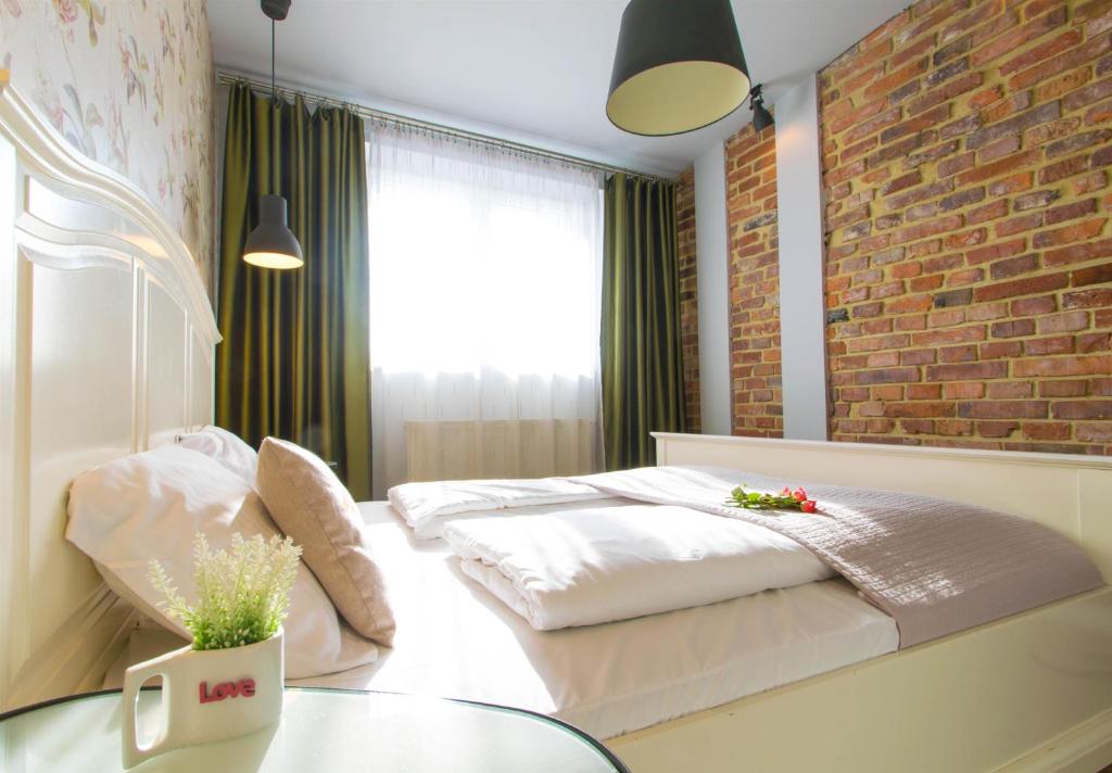 1 dormitorio con cama y pared de ladrillo en Krupnicza Modern Old Town Apartments en Cracovia