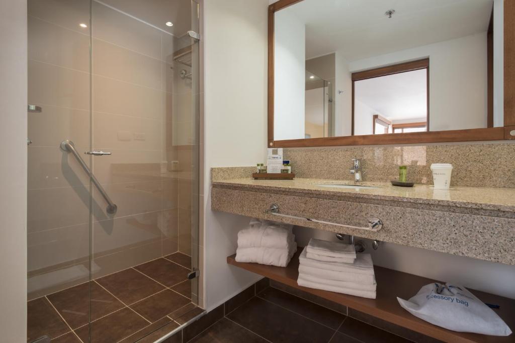 a bathroom with a shower and a sink and a mirror at Hotel Habitel Select in Bogotá