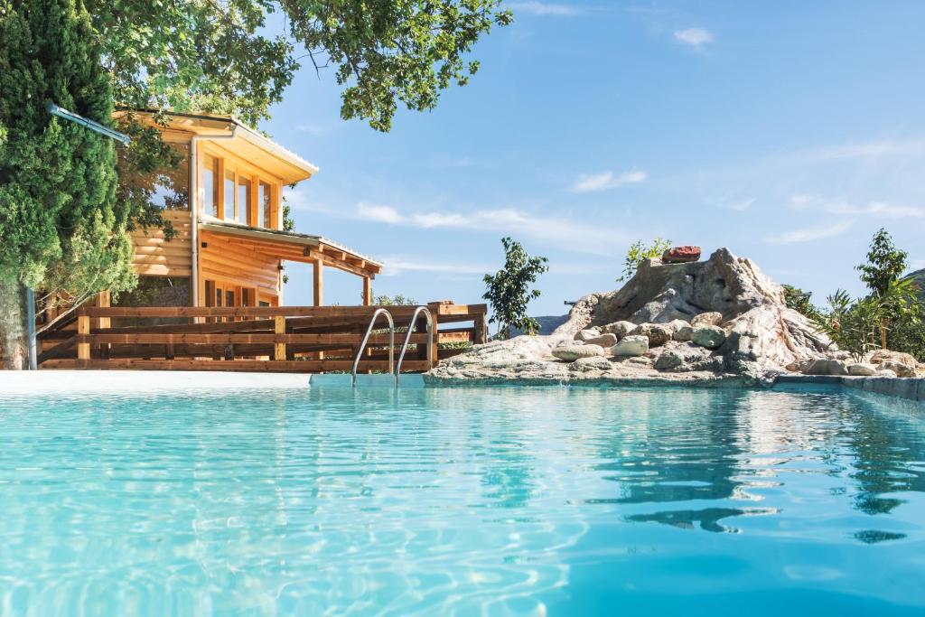 ein Blockhaus mit einem Pool und einem Haus in der Unterkunft Romantic Tree House in Kato Pavliana