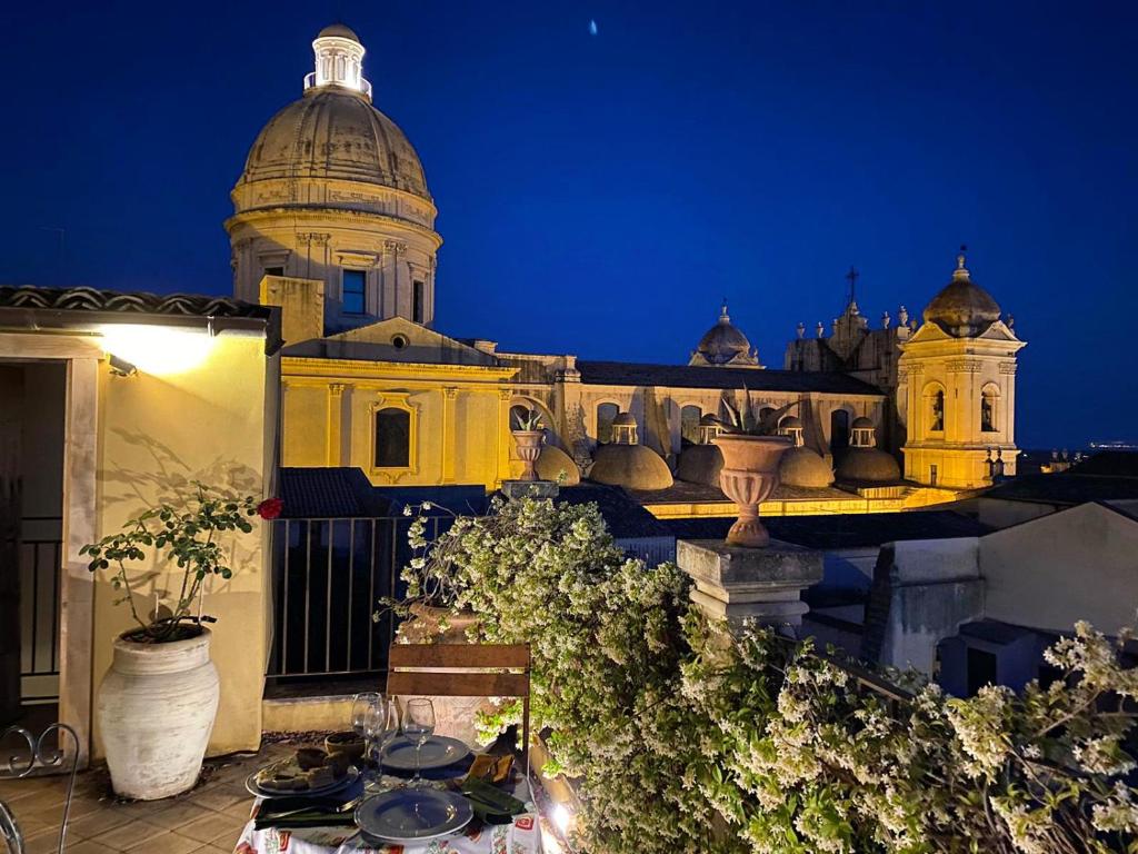 a view of a building at night with a table at Casa Modica - Luxury rooms in Noto