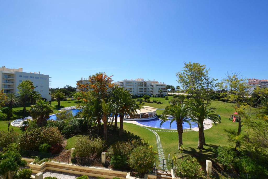 een park met palmbomen en een waterglijbaan bij Alvor Marachique Duplex in Alvor