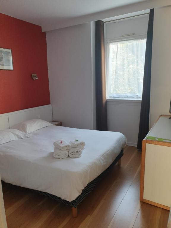 a bedroom with a bed with towels on it at Hôtel Hermance in Bellegarde-sur-Valserine