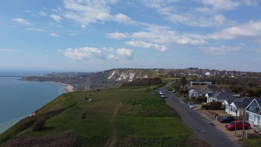 an aerial view of a hill with houses and the ocean at Sea View Bungalow in Hougham
