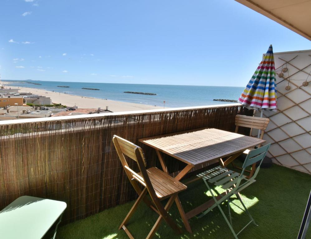 - Balcón con mesa y sillas y vistas a la playa en Appartement Valras 1ere ligne vue mer en Valras-Plage