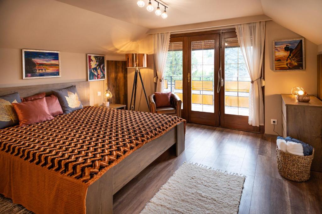 - une chambre avec un grand lit et un balcon dans l'établissement PelsoArt Apartments, à Keszthely