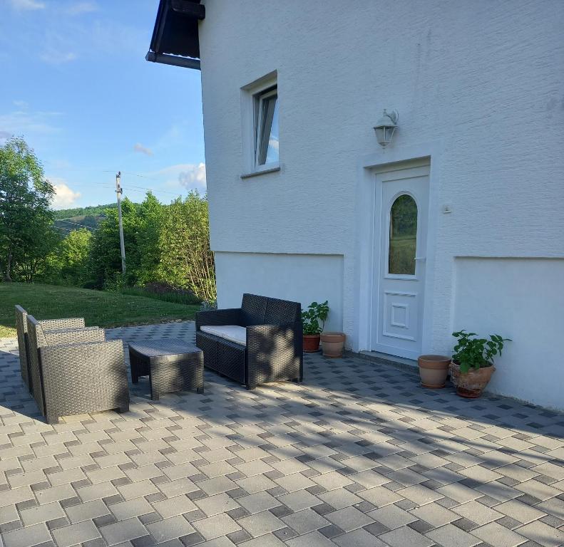 2 sedie su un patio di fronte a una casa bianca di Apartment Sučić a Seliste Dreznicko