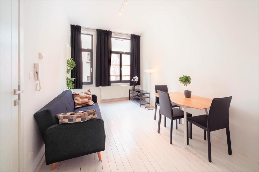 - un salon avec un canapé, une table et des chaises dans l'établissement Beautiful Cozy Apartments in the Heart of Antwerp, à Anvers