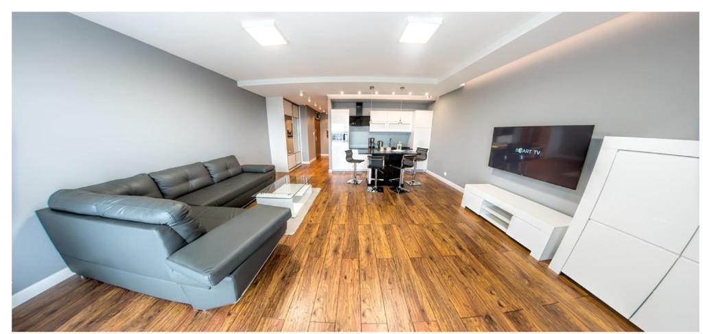 een woonkamer met een bank en een flatscreen-tv bij Apartament 75,143 Porta Mare in Dziwnówek