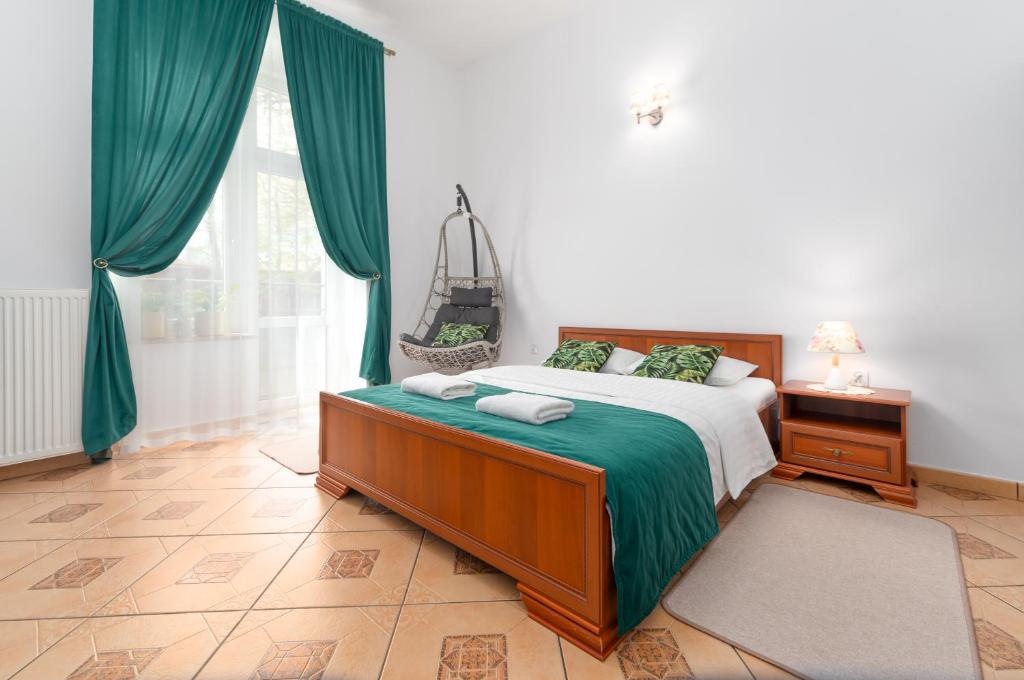 sypialnia z łóżkiem z zieloną pościelą i oknem w obiekcie Nasze Kamienice Apartament Muzyczny z antresolą w mieście Rzeszów