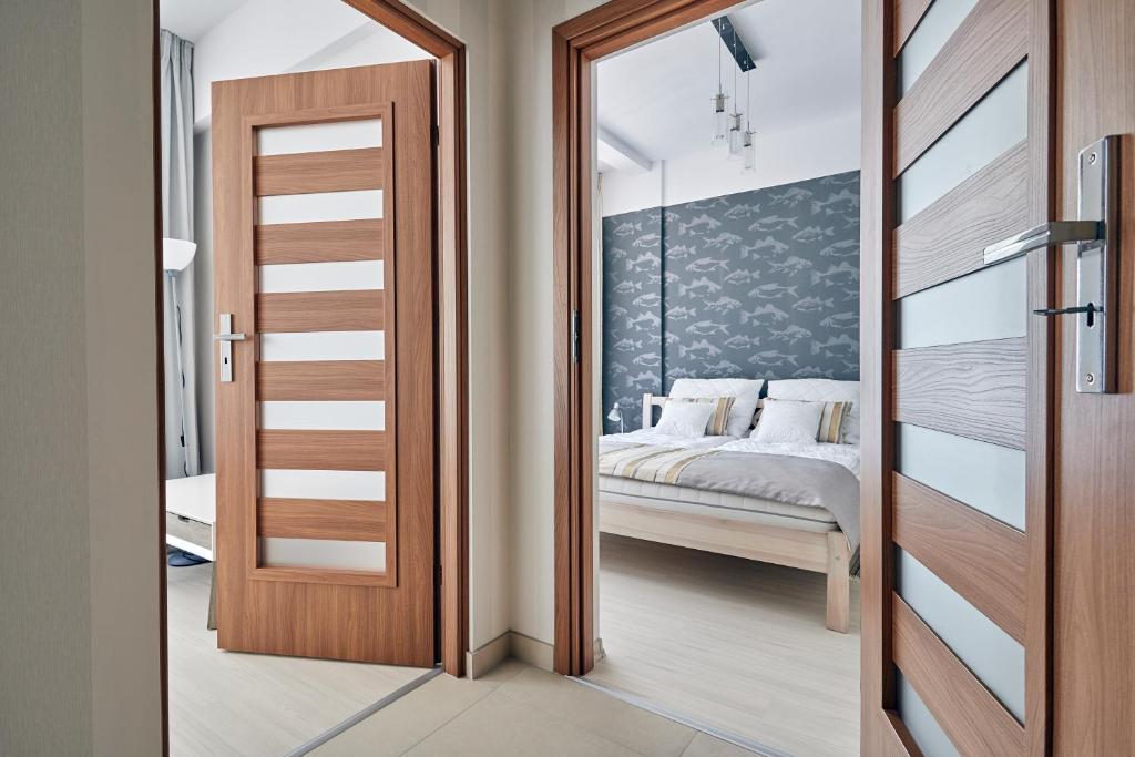 Schlafzimmer mit einer Tür, die zu einem Bett führt in der Unterkunft Apartamenty Turystyczna Małgorzata in Misdroy