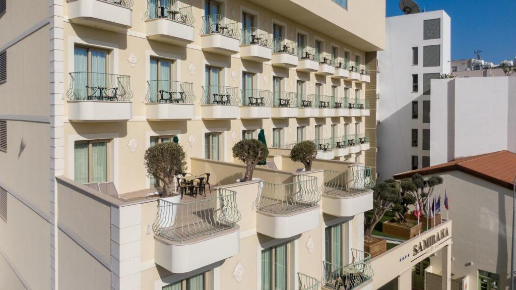 an apartment building with potted plants on the balconies at Leonardo Boutique Hotel Larnaca in Larnaca