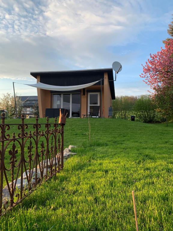 a house with a fence in front of a yard at Piccola Casa in Hainewalde