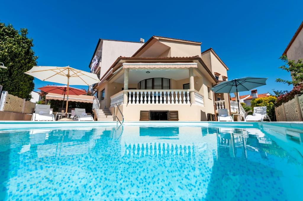 una villa con piscina di fronte a una casa di Villa Allegria a Rovigno (Rovinj)
