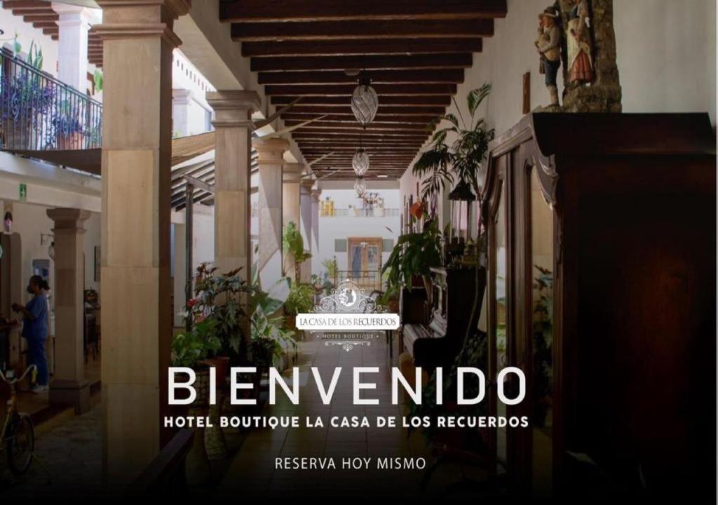 a sign in the middle of a building with plants at Hotel-Boutique La Casa De Los Recuerdos in Zitácuaro