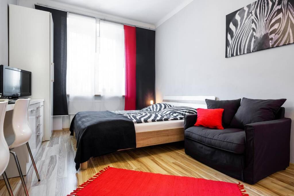 a small bedroom with a bed and a couch at Studio Pomorska , bezpłatny parking in Krakow