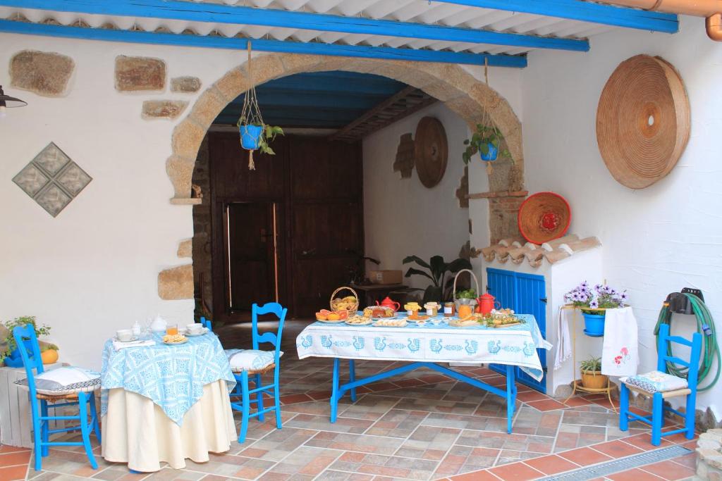 una mesa con sillas azules y una mesa con comida. en B&B Piazza Municipio, en San Vito