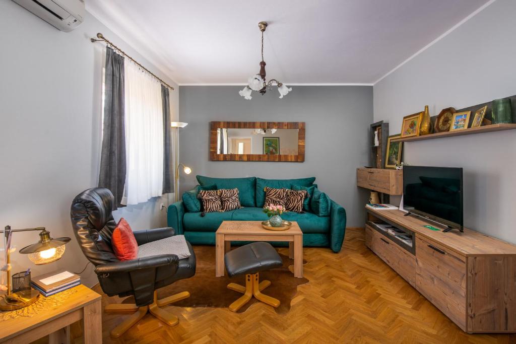 uma sala de estar com um sofá verde e uma televisão em Apartment Green 29 em Rovinj