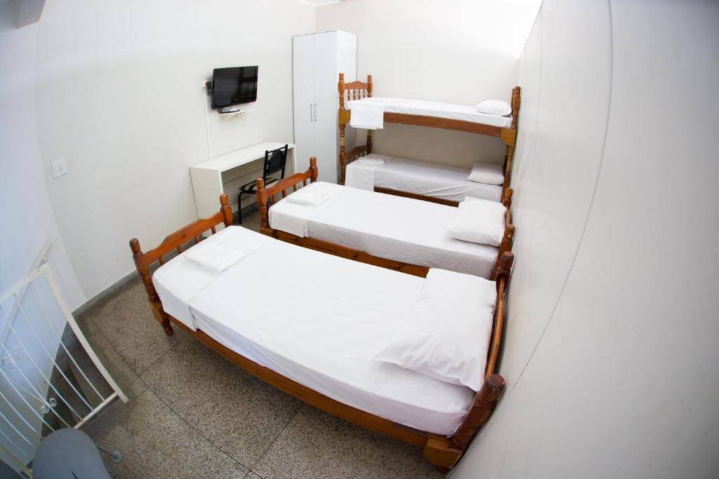 a room with three bunk beds and a tv at Apartamento ou Flat no Centro in Campinas