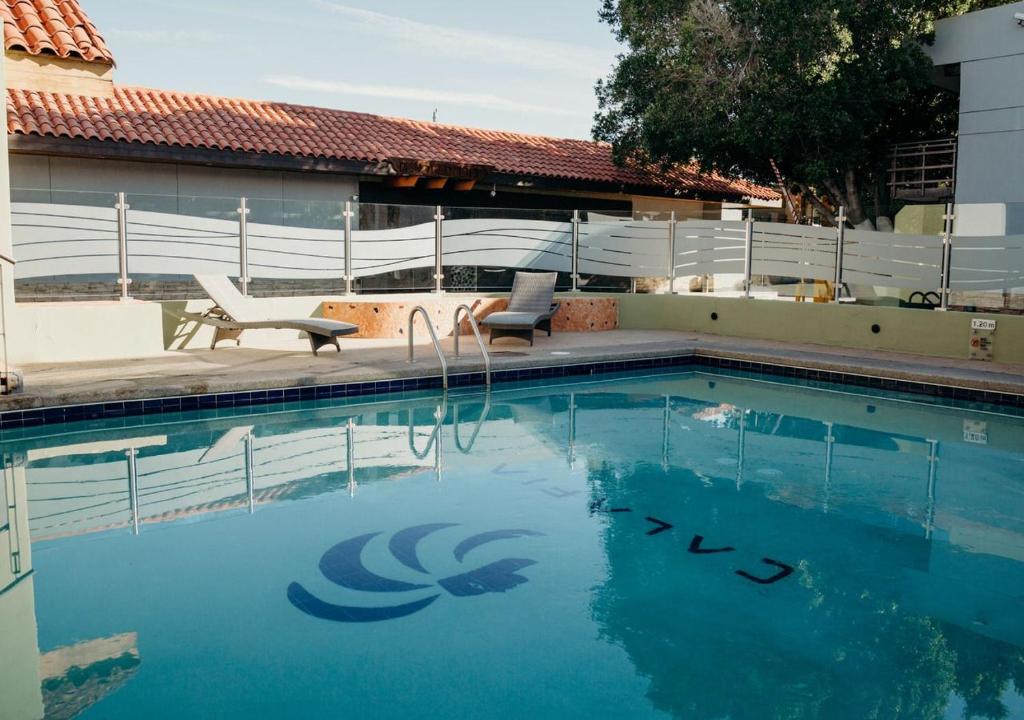 a swimming pool with blue water in front of a house at Hotel Calafia in Mexicali