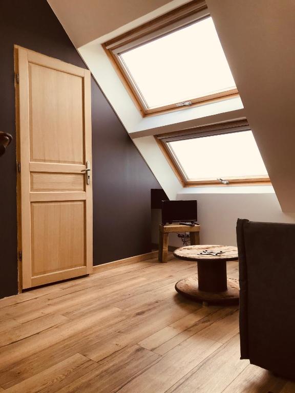- une chambre avec 2 lucarnes, une porte et une table dans l'établissement Studio Escapade Normande proche Etretat, à Saint-Jouin-Bruneval