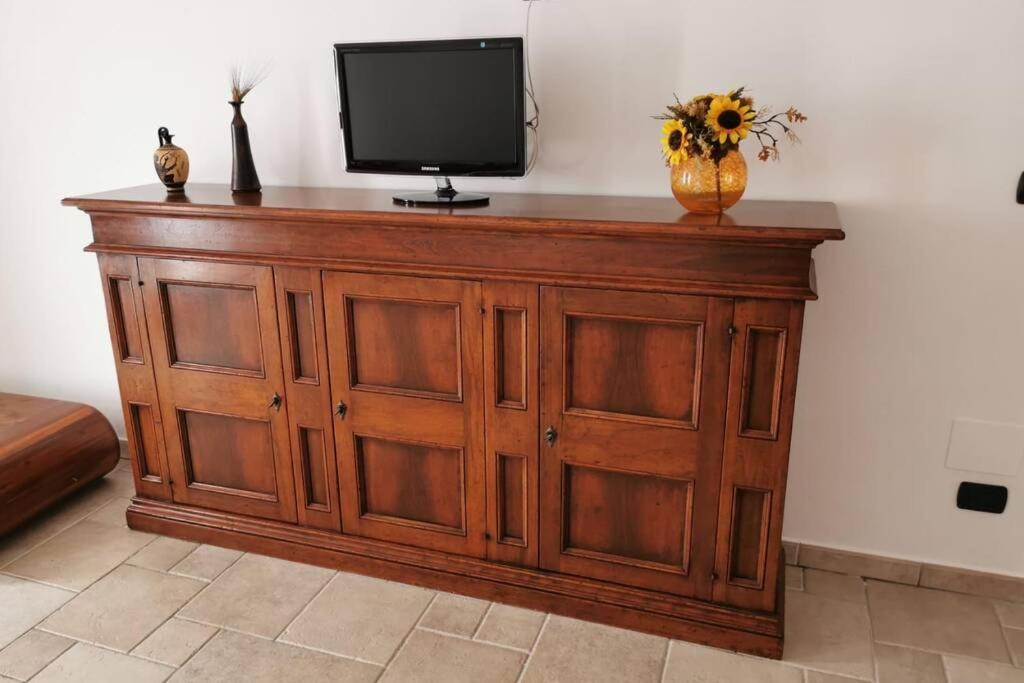 a wooden cabinet with a television on top of it at Intera casa appena ristrutturata in Parabita