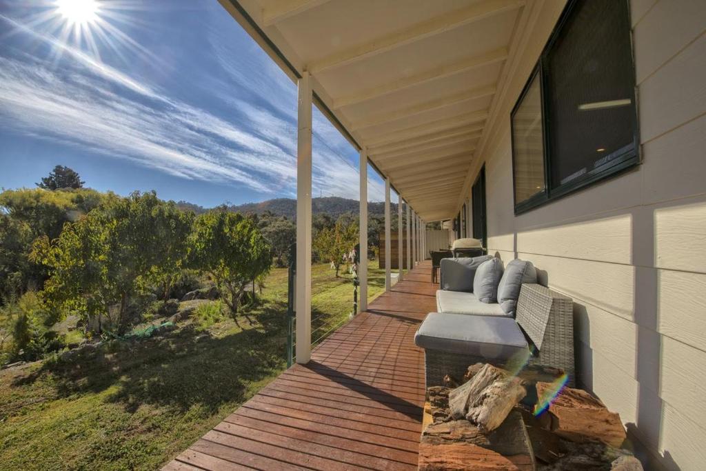 a porch with a couch on the side of a house at East Jindabyne- Cavallino 4 bedroom home in Jindabyne