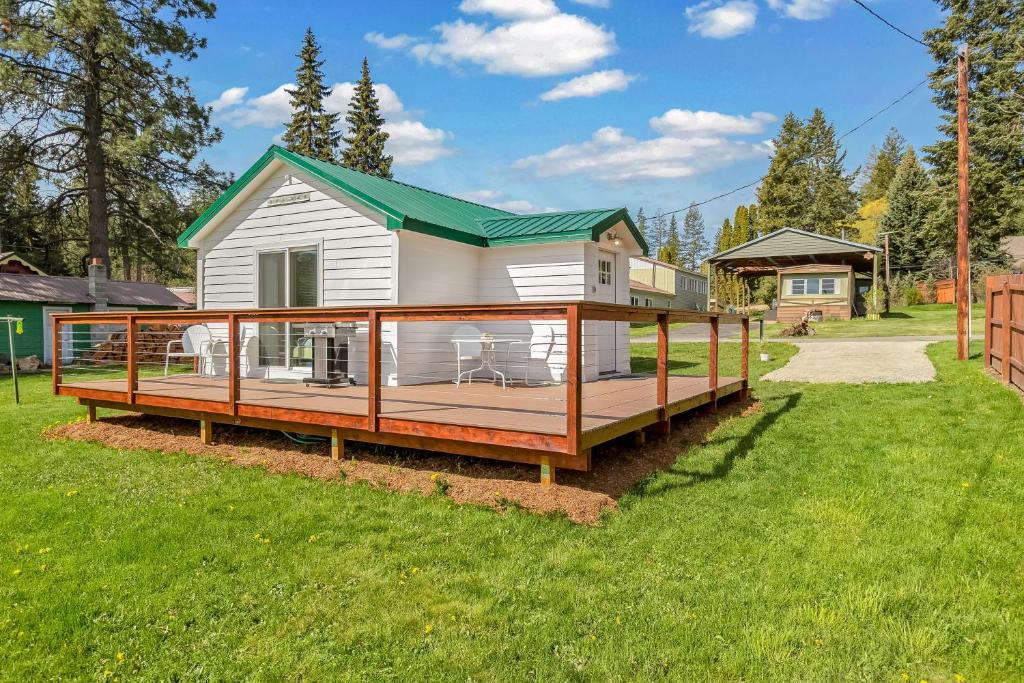 a house with a large deck on a yard at Bayview Tiny Cabin in Athol