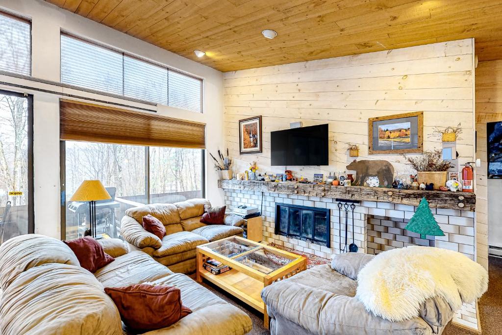 a living room with couches and a fireplace at Delightful Seclusion in Stratton
