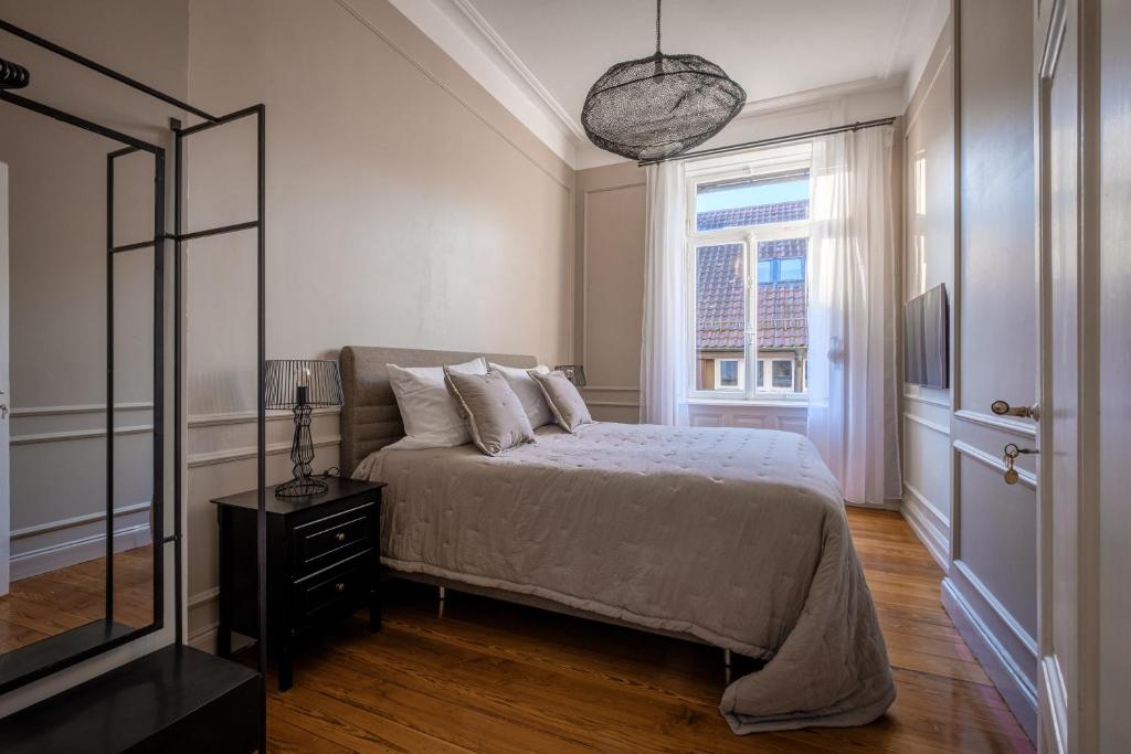 Schlafzimmer mit einem Bett, einem Spiegel und einem Fenster in der Unterkunft Boutique Charme Apartment Ricarda in Baden-Baden