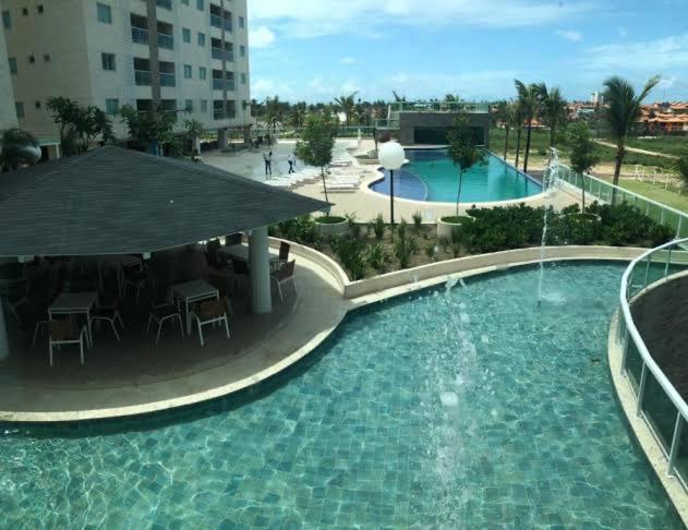 a large swimming pool with tables and chairs in a building at Salinas Park Resort in Salinópolis