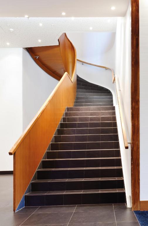a set of stairs in a building with wooden railings at Radisson Blu Hotel, Trondheim Airport in Stjoerdal