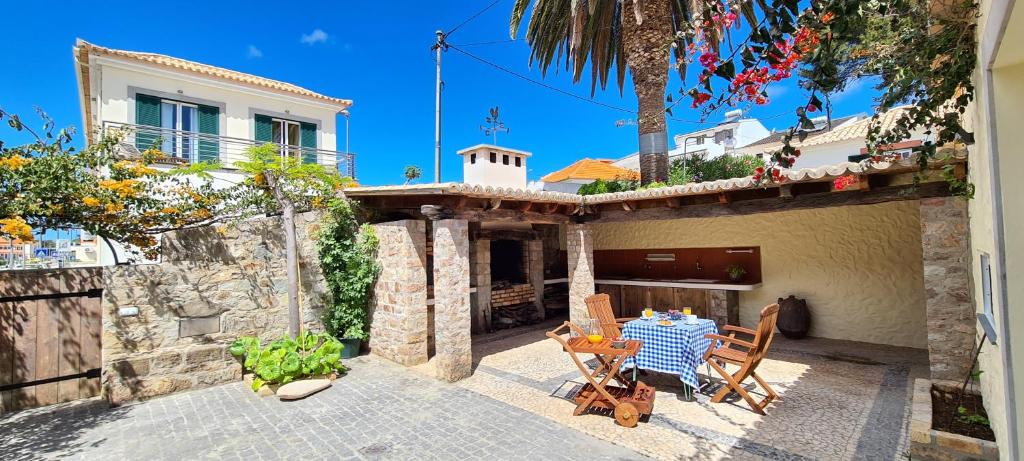 una casa y un patio con mesa y sillas en Catavento en Porto Santo