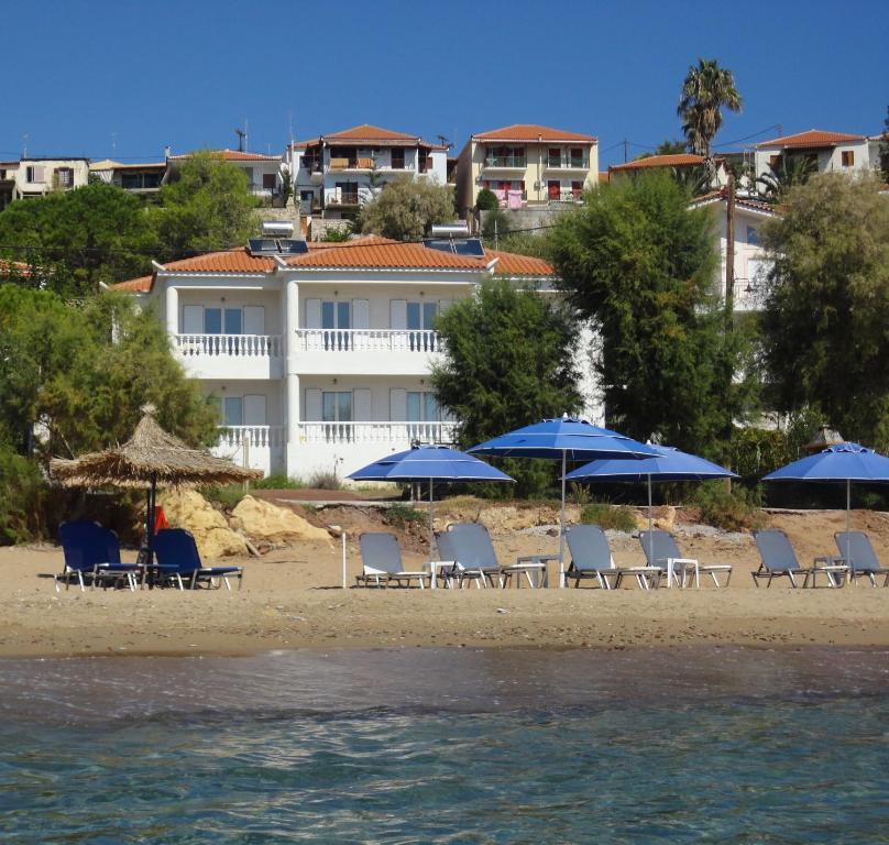 a group of chairs and umbrellas on a beach at Akti Zaga Apartments in Koroni