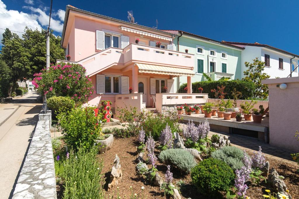 a house with a garden in front of it at Apartment Oleander in Punat