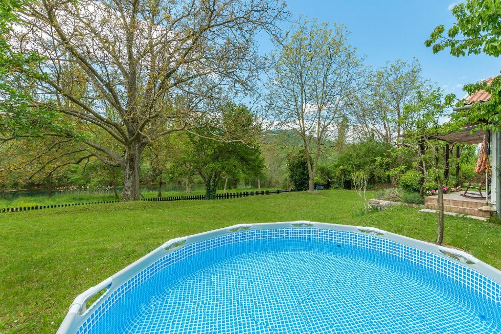 a blue swimming pool in the yard of a house at House Zetna in Blato na Cetini