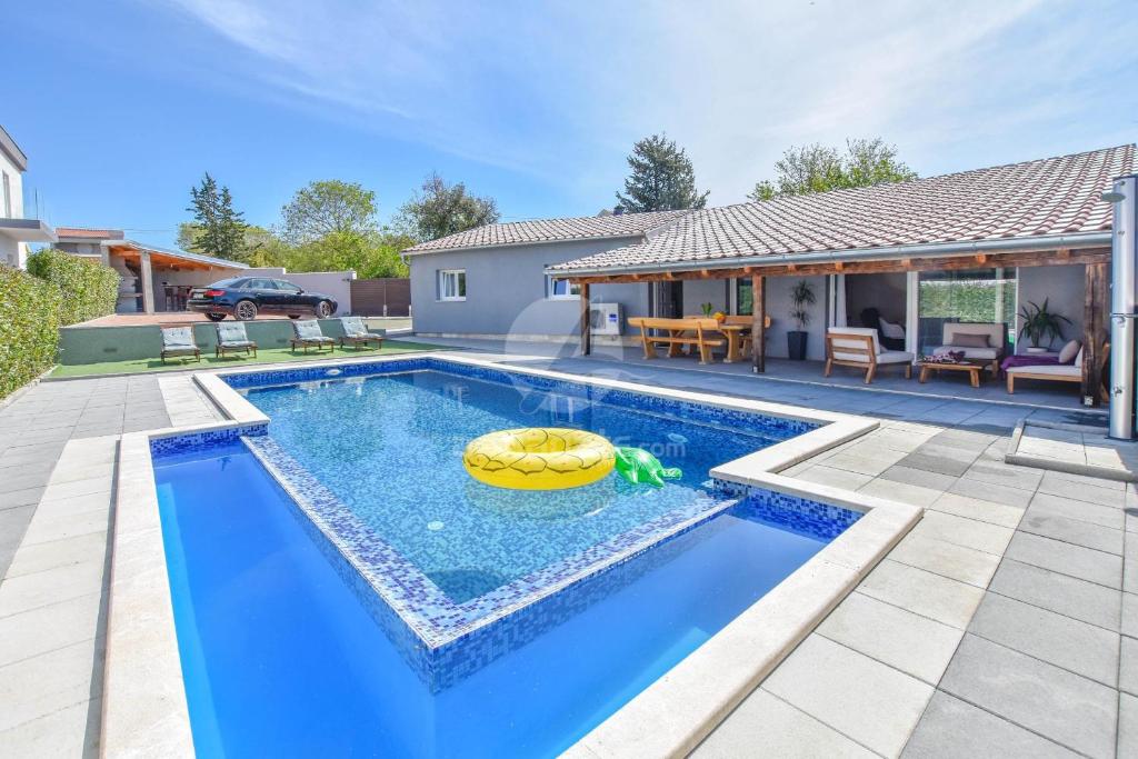 a swimming pool with a yellow raft in a house at Villa Pave in Pakoštane