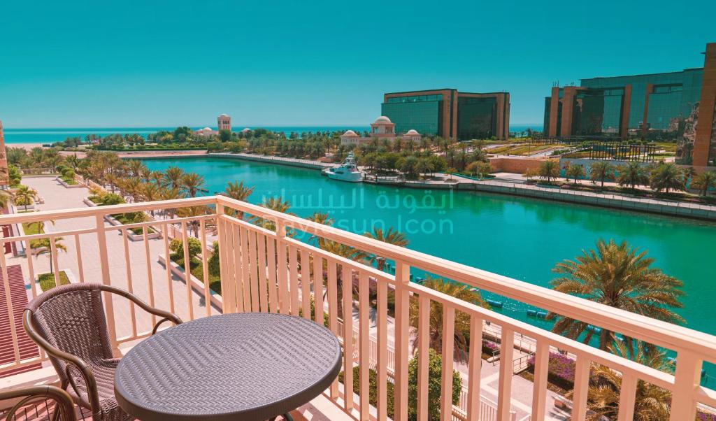 einen Balkon mit einem Tisch und Blick auf das Wasser in der Unterkunft Baylasun Icon in King Abdullah Economic City