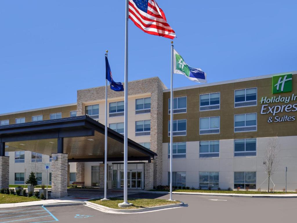 a hotel with two flags in front of a building at Holiday Inn Express & Suites - Brighton South - US 23 by IHG in Brighton