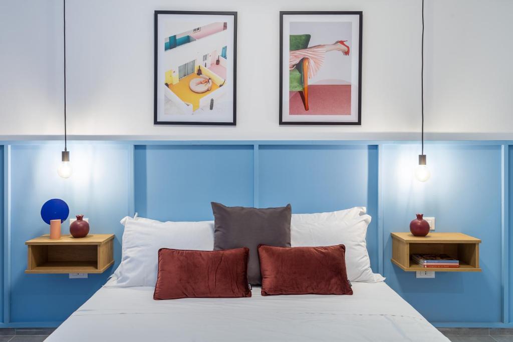 Schlafzimmer mit blauen Wänden und einem Bett mit roten Kissen in der Unterkunft Stylish loft in the city center in Triest