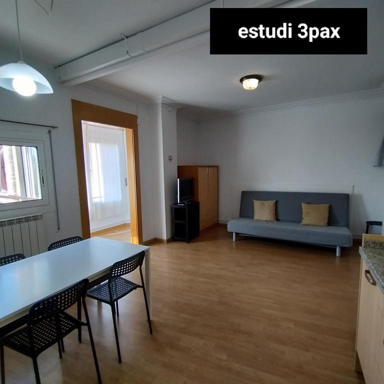 uma sala de estar com um sofá, uma mesa e cadeiras em Apartament Berga em Berga