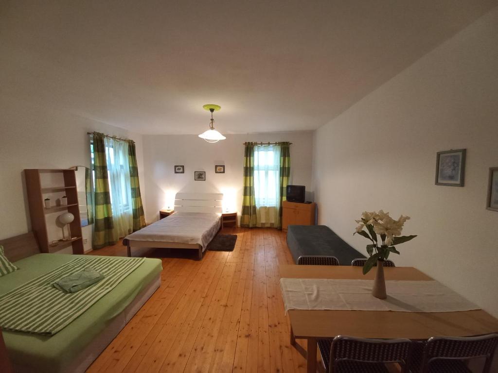 a living room with two beds and a table at Penzionek U Františka in Mařenice