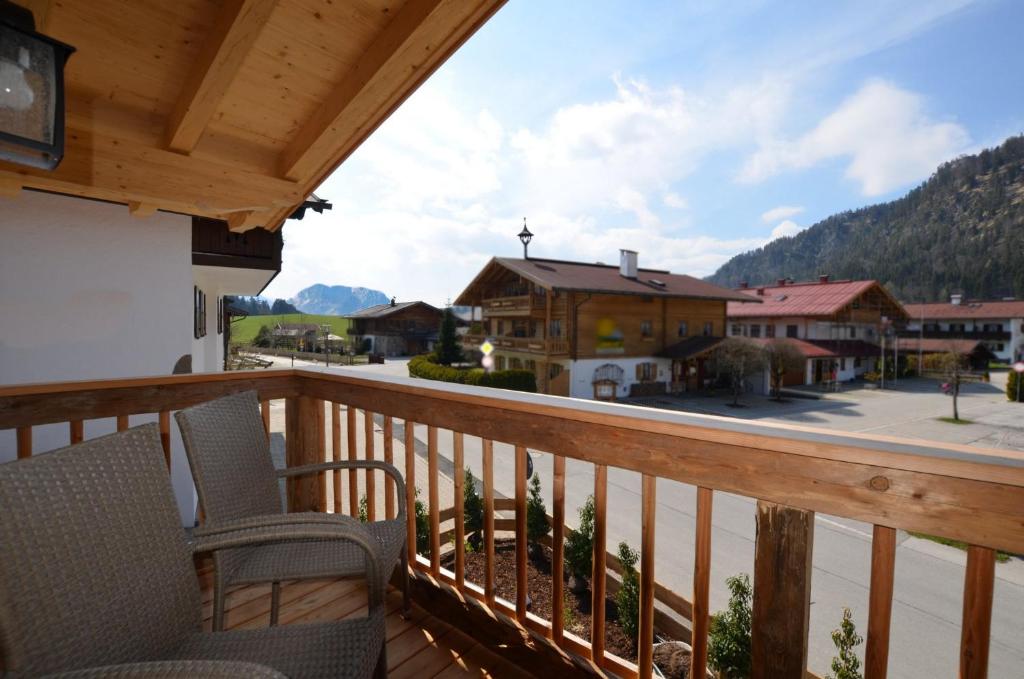 a balcony with chairs and a view of a town at Chalet Kaisereck in Reit im Winkl