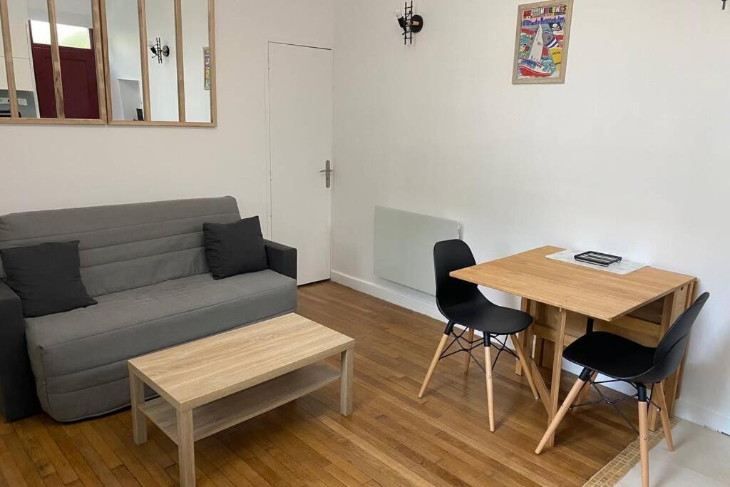 ein Wohnzimmer mit einem Sofa, einem Tisch und Stühlen in der Unterkunft Appartement centre ville de Dieppe in Dieppe