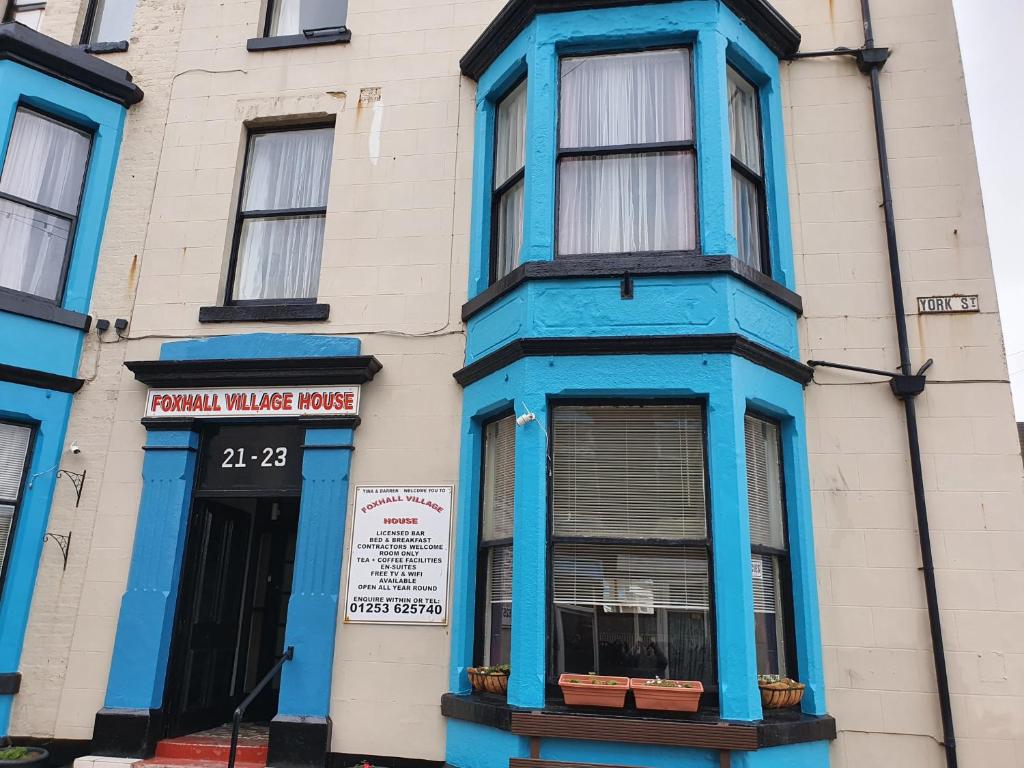 a building with blue trim on a street at Foxhall Village Guest House in Blackpool